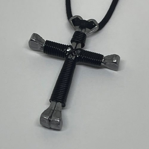 A horseshoe nail cross necklace wrapped with thin black wire