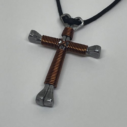 A horseshoe nail cross necklace wrapped with thin brown wire