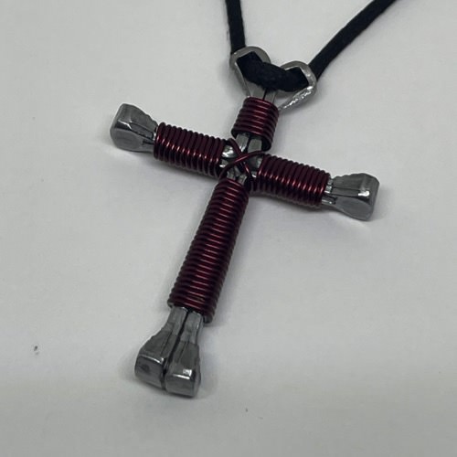 A horseshoe nail cross necklace wrapped with thin burgandy wire