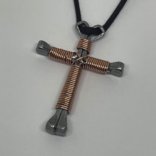 A horseshoe nail cross necklace wrapped with thin copper wire
