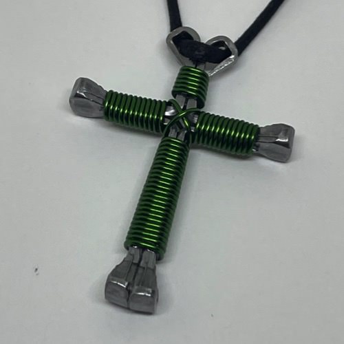 A horseshoe nail cross necklace wrapped with thin green wire