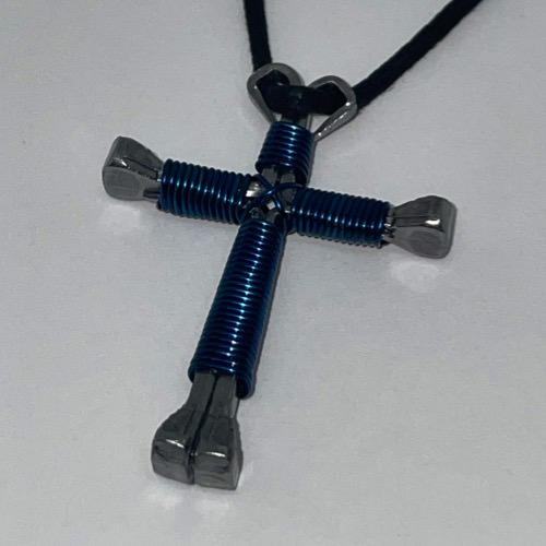 Navy horseshoe nail cross necklace on a black cord.