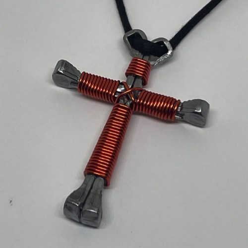 orange horseshoe nail cross necklace on a black cord.