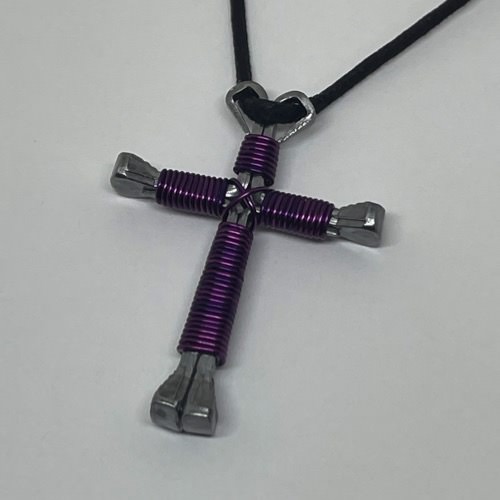 A horseshoe nail cross necklace wrapped with thin purple wire 
