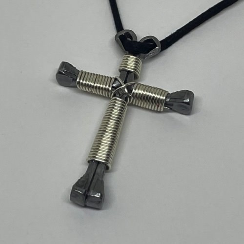 A horseshoe nail cross necklace wrapped with thin shiny wire