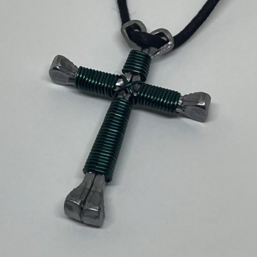 A horseshoe nail cross necklace wrapped with thin teal wire 