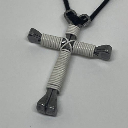A horseshoe nail cross necklace wrapped with thin white wire
